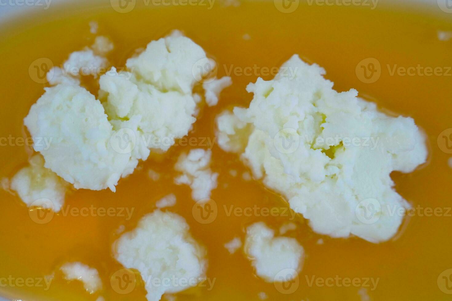 butter cream and honey in a bowl on table . photo
