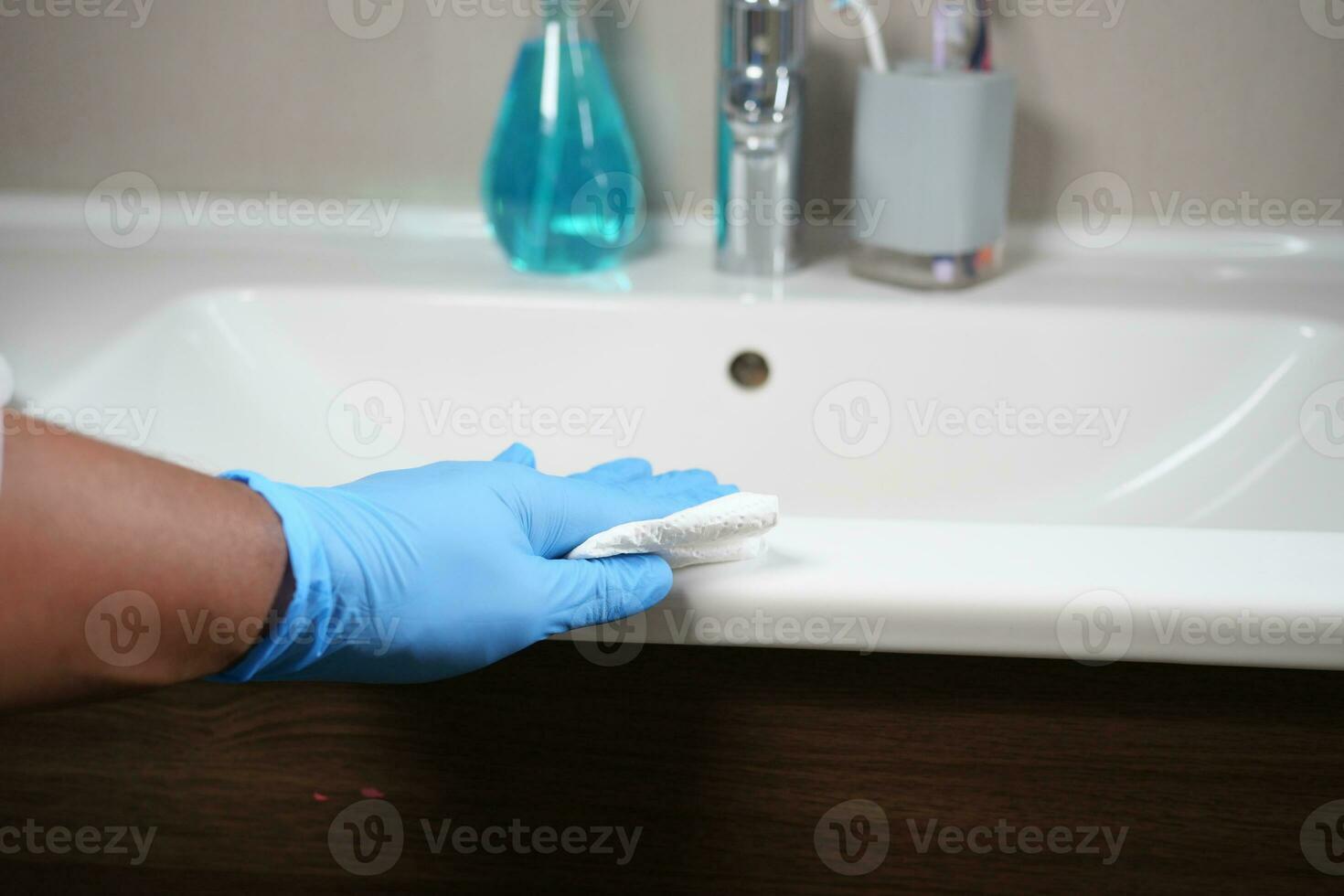 Hand in gloves cleaning the bathroom photo