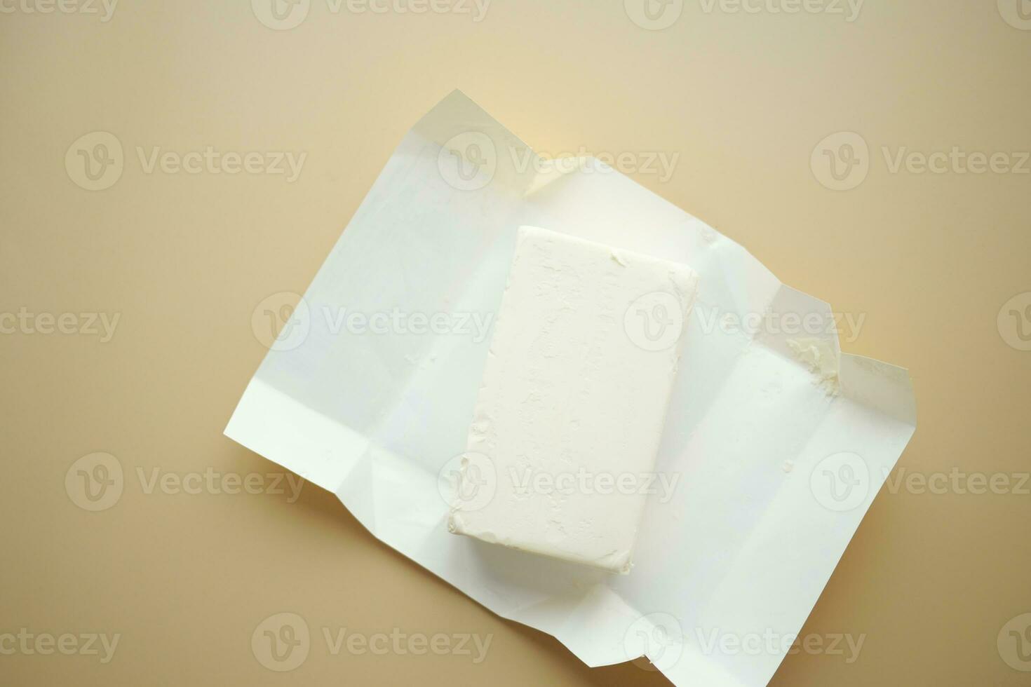 slice of a butter on a paper on table photo