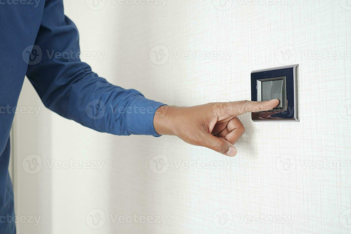 A finger turning on lighting switch . photo