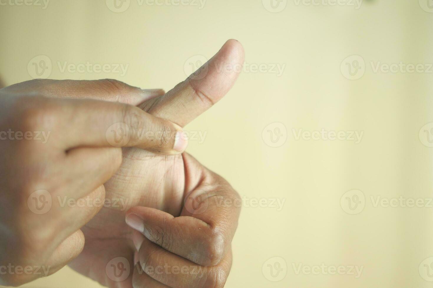 man suffering pain in thumb finger close up photo