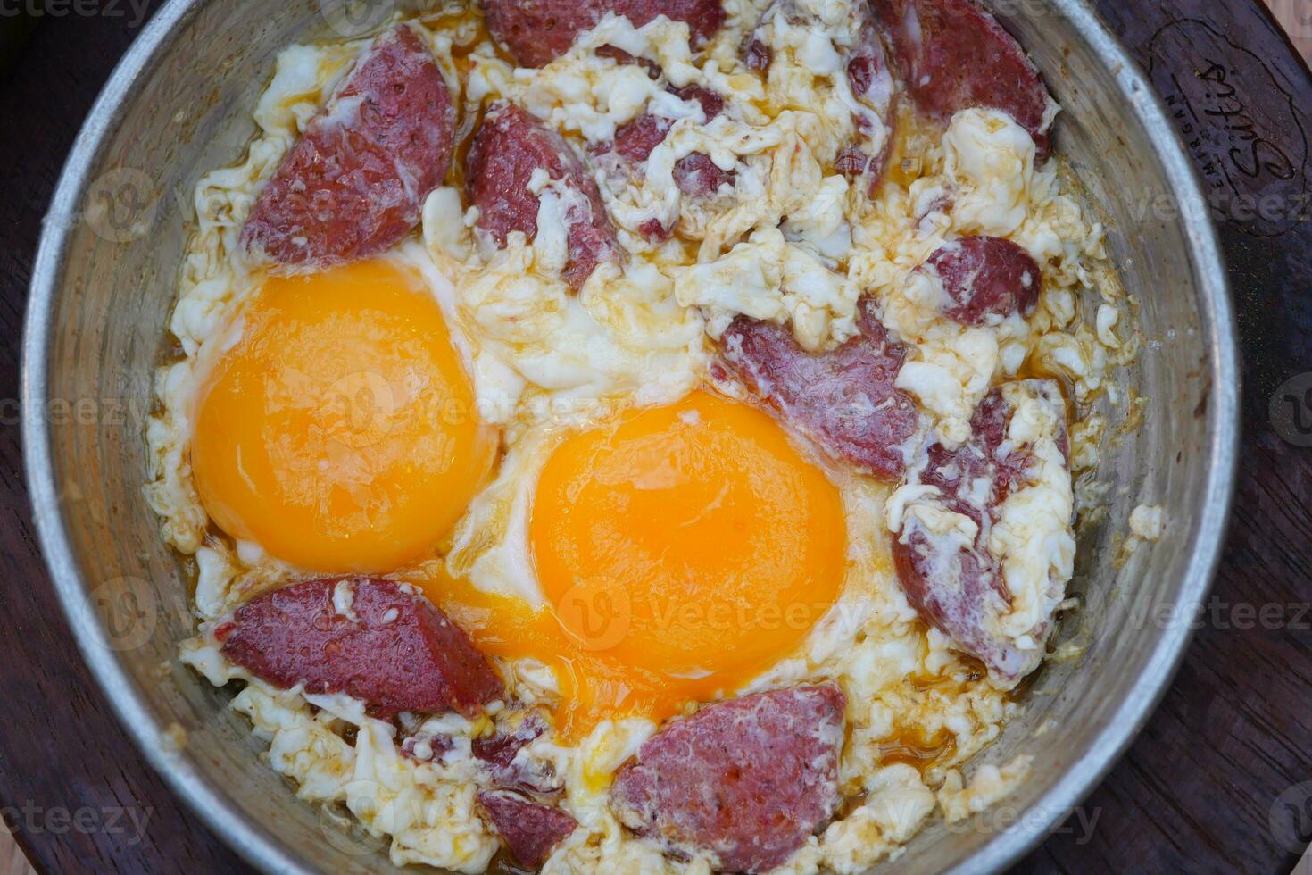 fried egg mixed with sausage in a pan photo