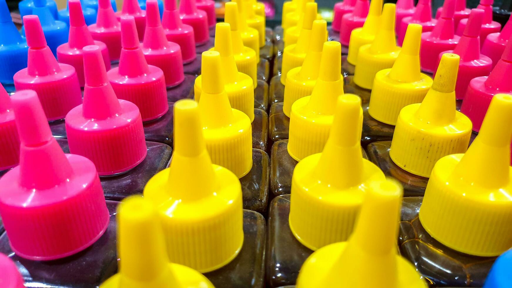 Closeup and crop colorful Ink bottle cap sell in office equipment store fit on screen background photo