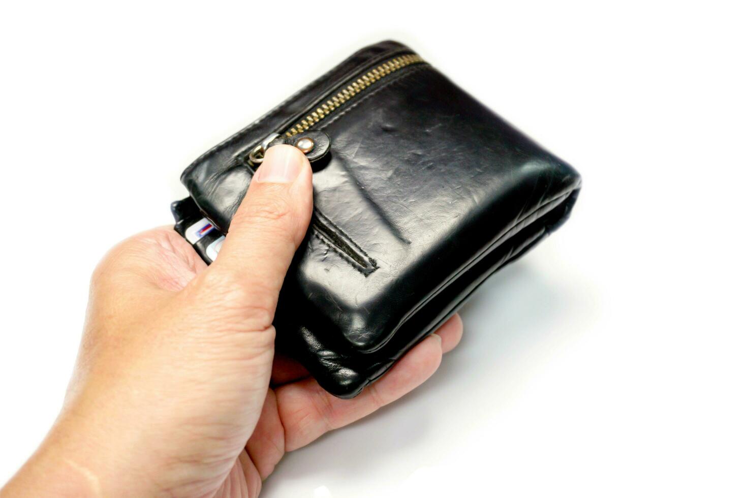 Closeup hand of human holding a black men's leather wallet isolate on white background and make with paths. photo