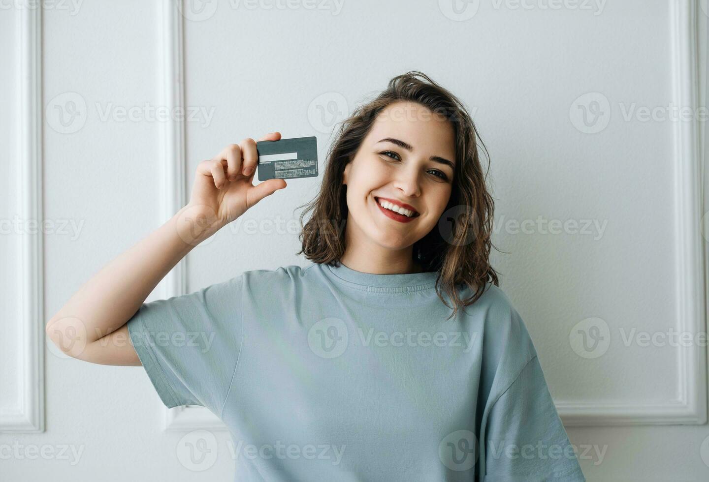 positivo de edad mediana mujer demostración crédito tarjeta en de cerca estudio disparo. contento de edad mediana dama presentación crédito tarjeta, estudio de cerca. de edad mediana mujer sonriendo, participación crédito tarjeta foto