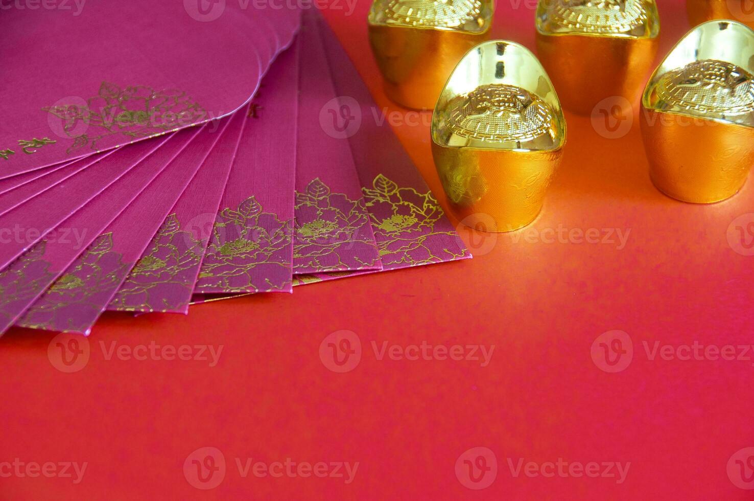 Red envelope and golden ingots on red cover background with Chinese New Year wishes. photo