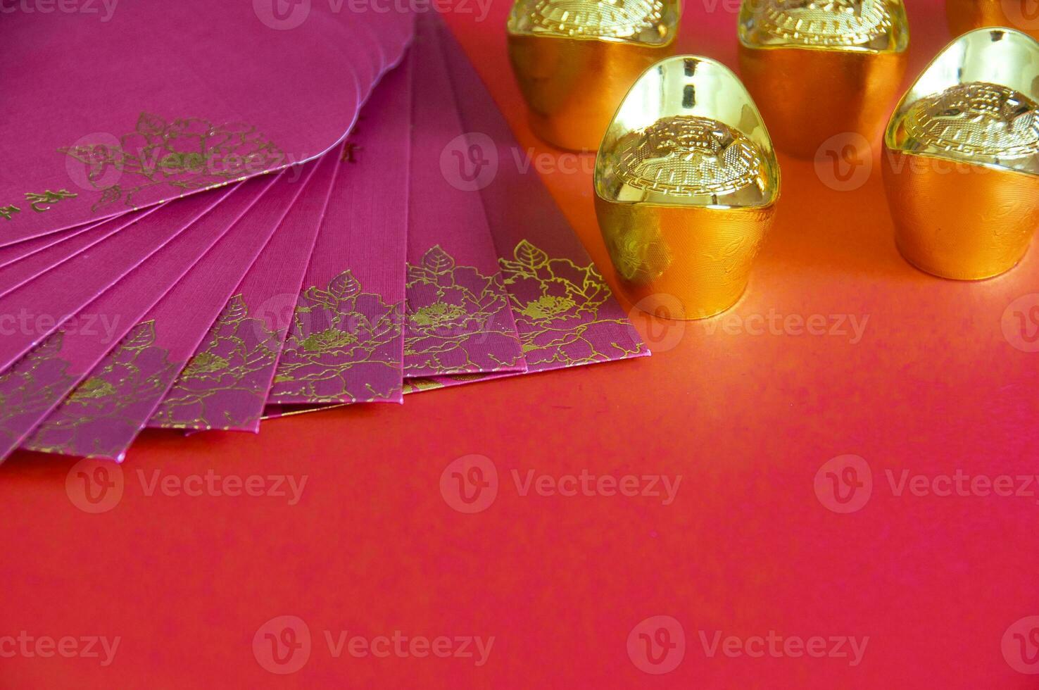 Red envelope and golden ingots on red cover background with Chinese New Year wishes. photo