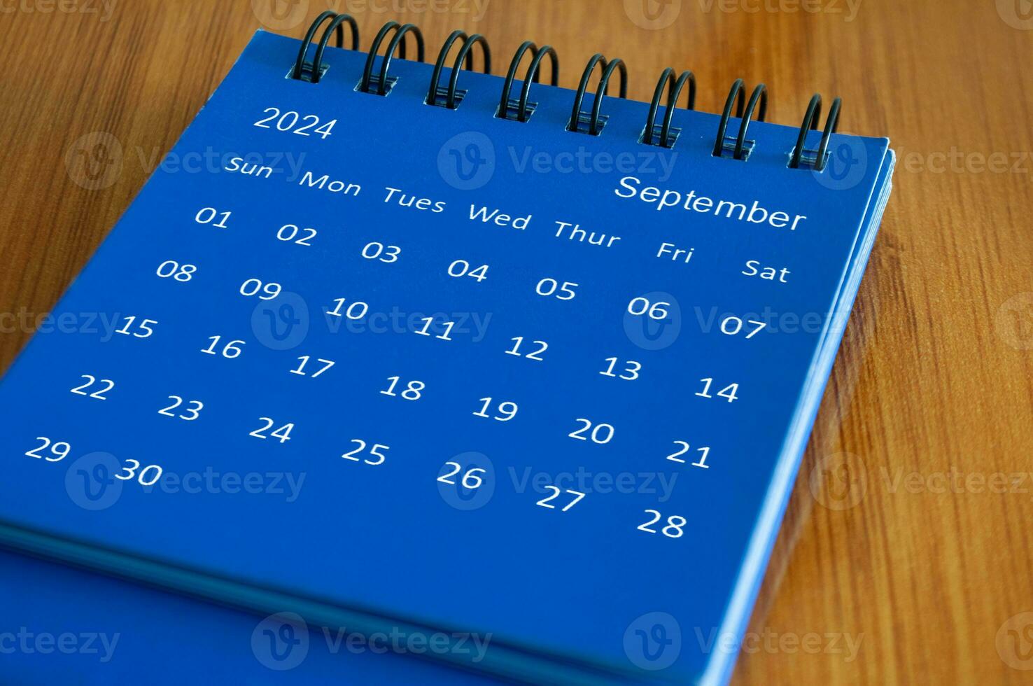 September 2024 table calendar on wooden desk. Time and calendar concept photo