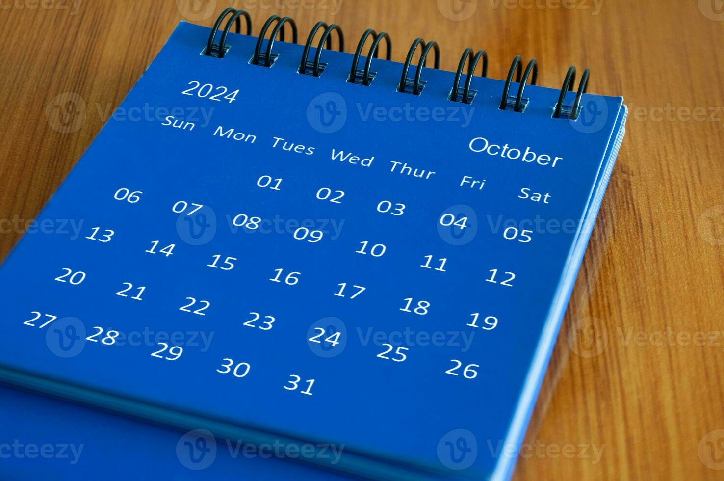 October 2024 table calendar on wooden desk. Time and calendar concept photo