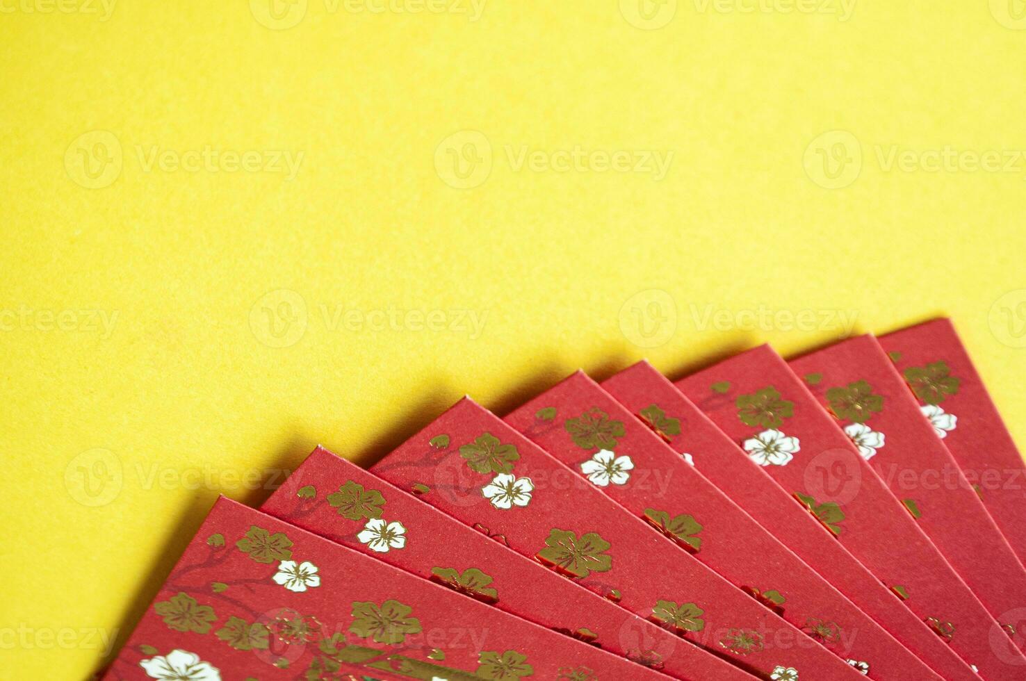 Top view of red envelopes with golden coins on yellow cover with customizable space for text photo