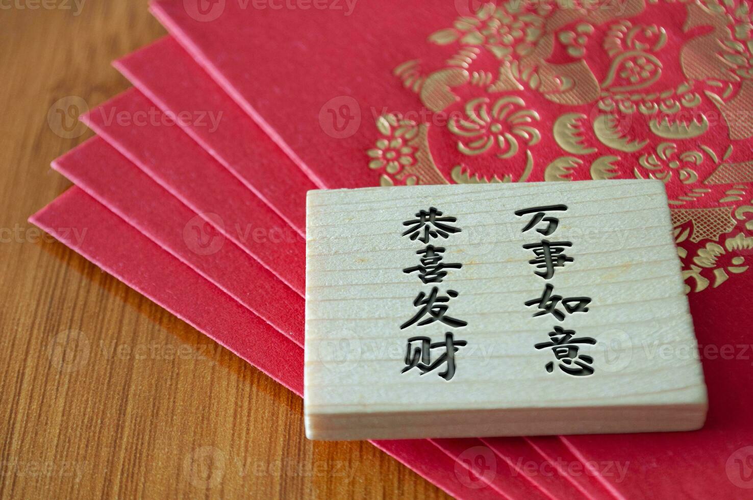 Close up view of Chinese New Year red packets with Chinese New Year wishes on wooden block photo