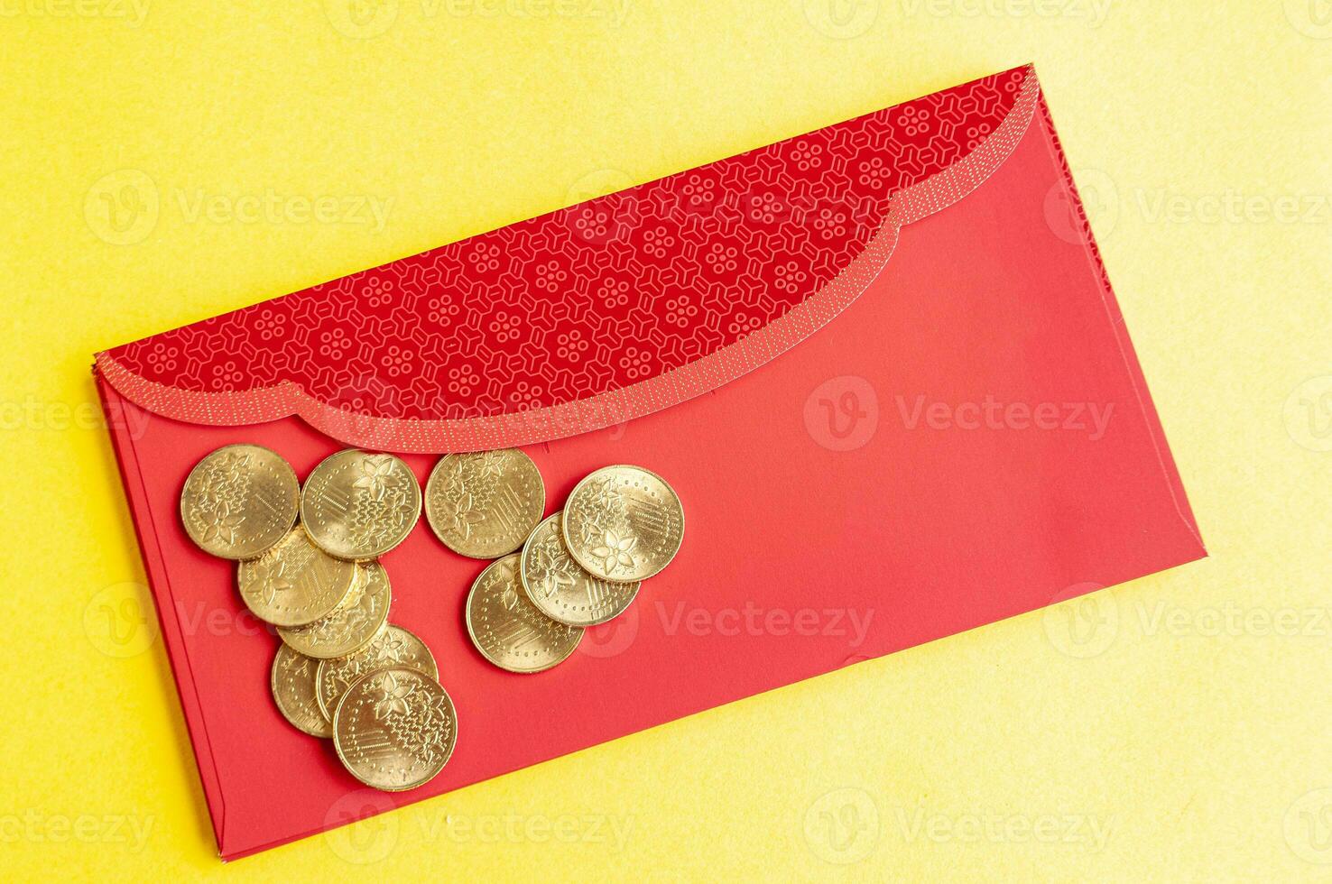 Top view of red envelopes with golden coins on yellow cover with customizable space for text. photo