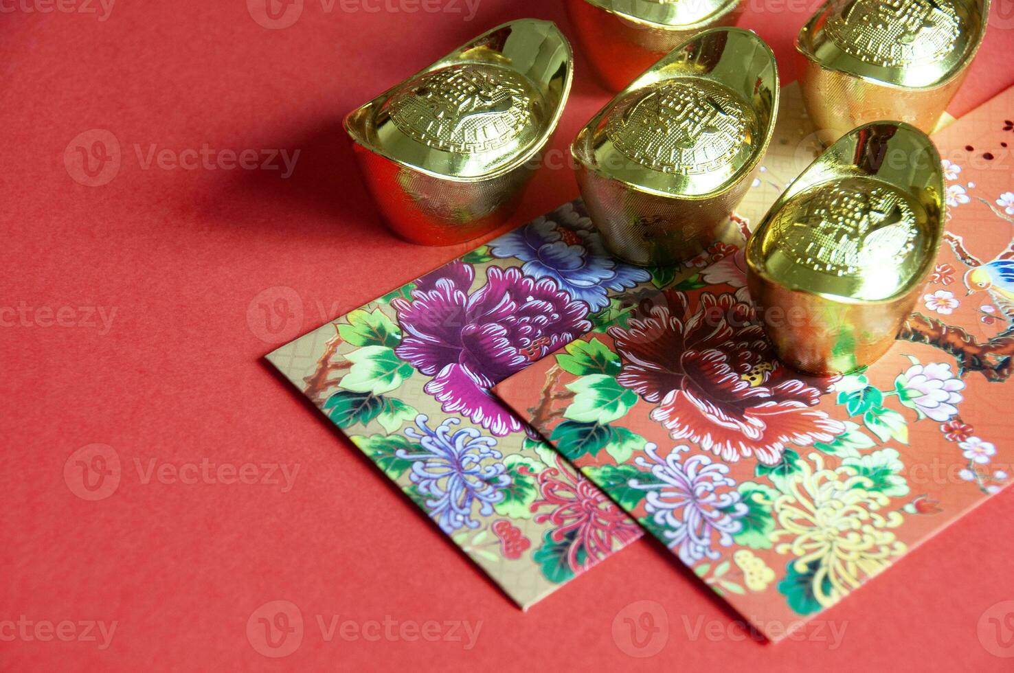 Colorful envelope and golden ingots on red cover background with Chinese New Year wishes photo