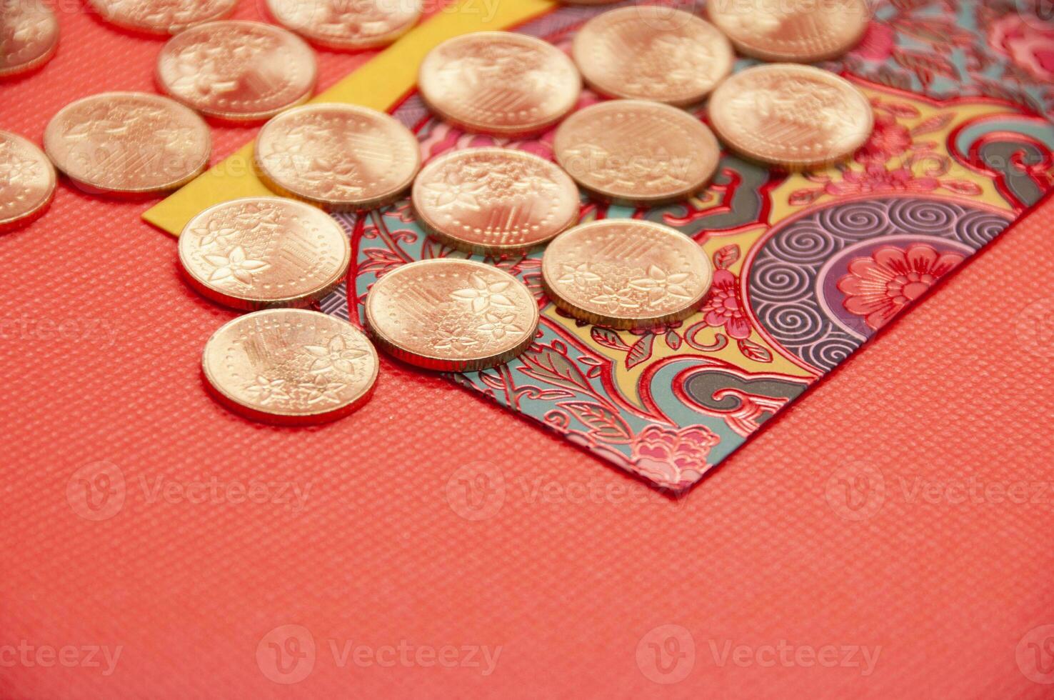 Close up of colorful envelope and golden coins on red cover background photo