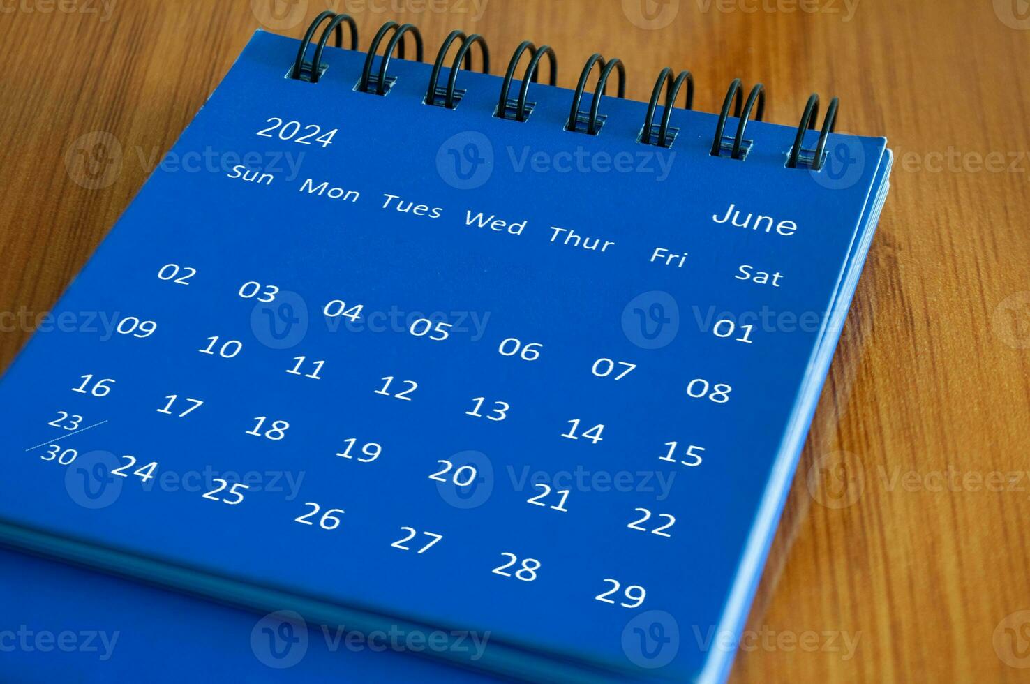 June 2024 table calendar on wooden desk. Time and calendar concept photo