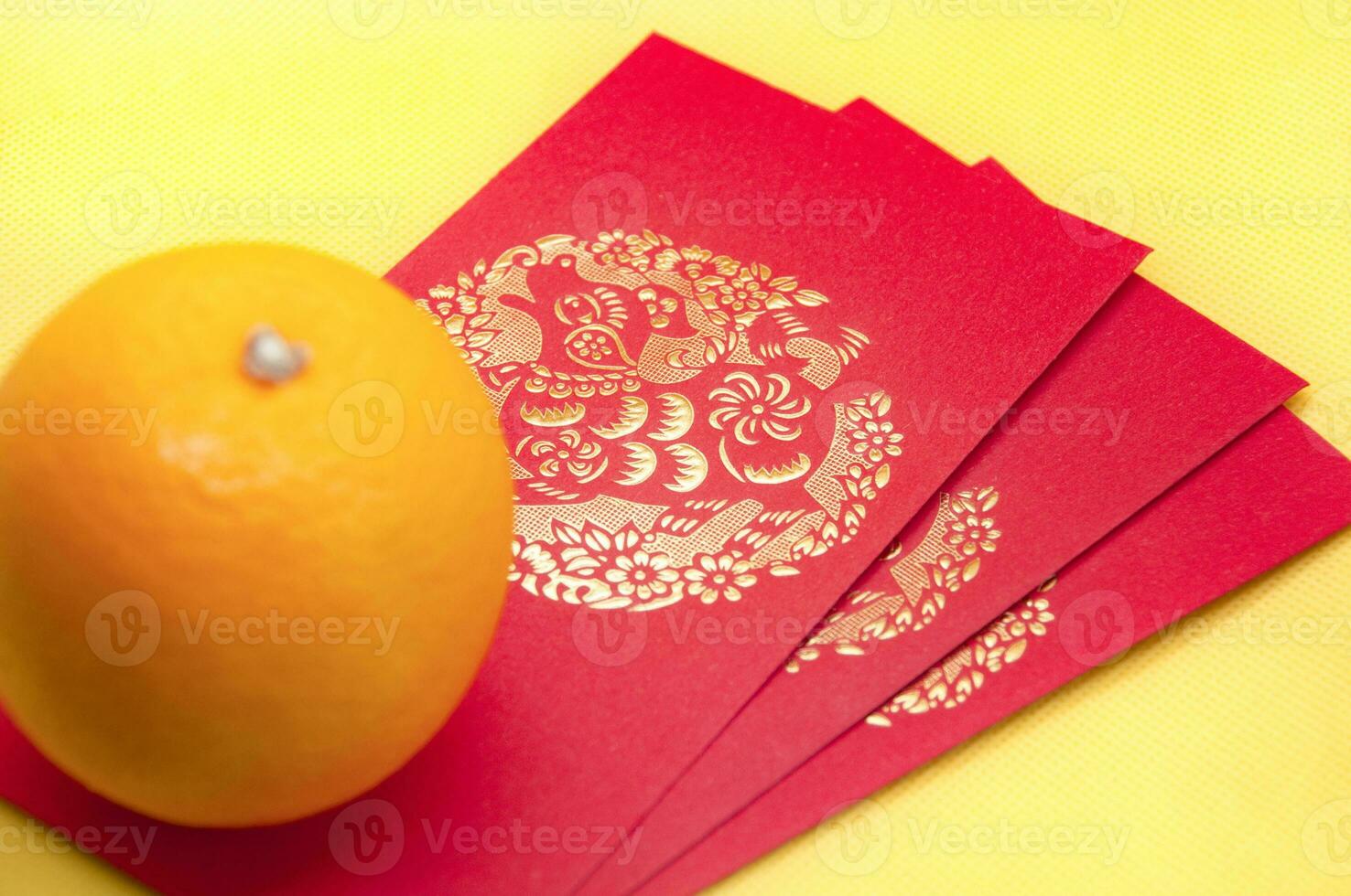 Chinese New Year red packets and orange on yellow cover background. Chinese festive season concept and copy space. photo