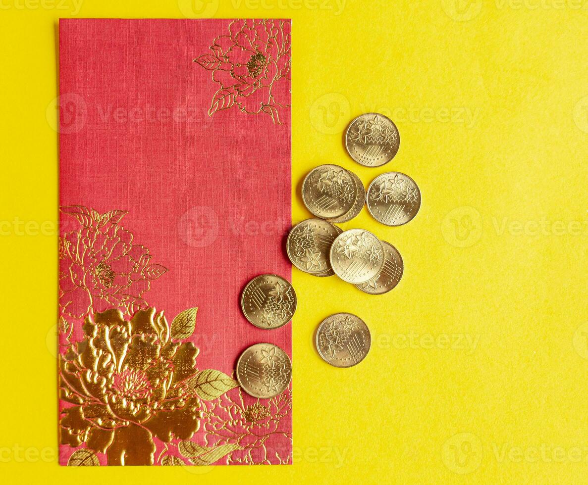 Top view of red envelopes with golden coins on yellow cover with customizable space for text photo