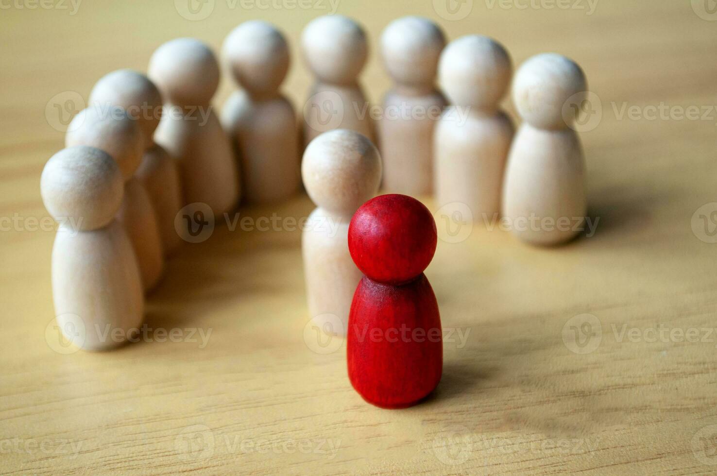 Red wooden doll surrounded with other dolls. Representing either leadership or harassment. photo