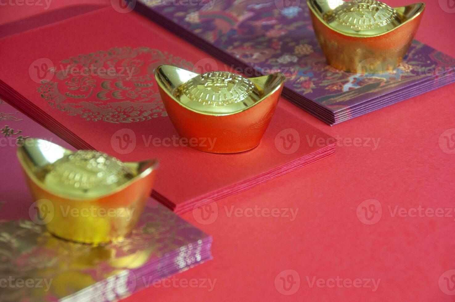 Red envelope and golden ingots on red cover background with Chinese New Year wishes photo