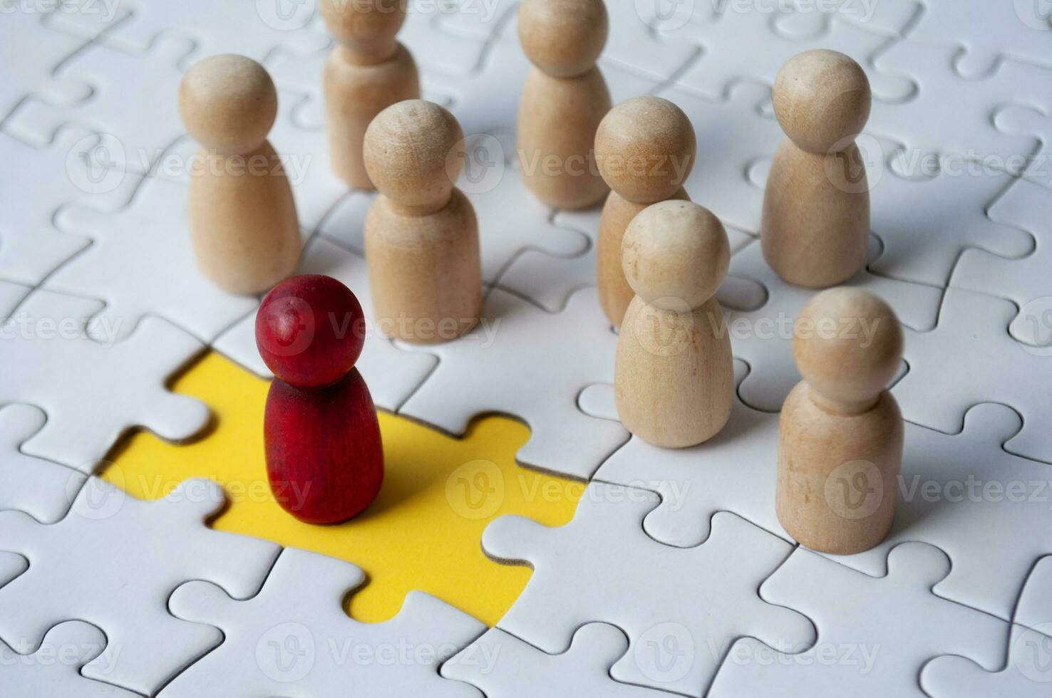 Wooden dolls on top of jigsaw with missing jigsaw puzzle. Hiring and employment concept photo
