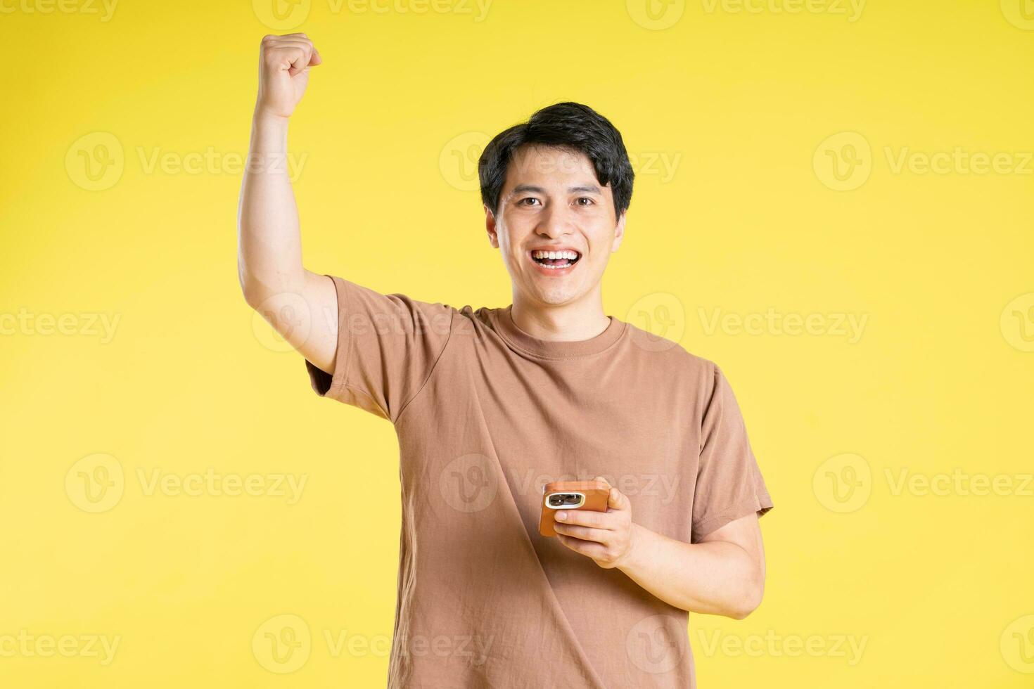 Portrait of asian man posing on yellow background photo