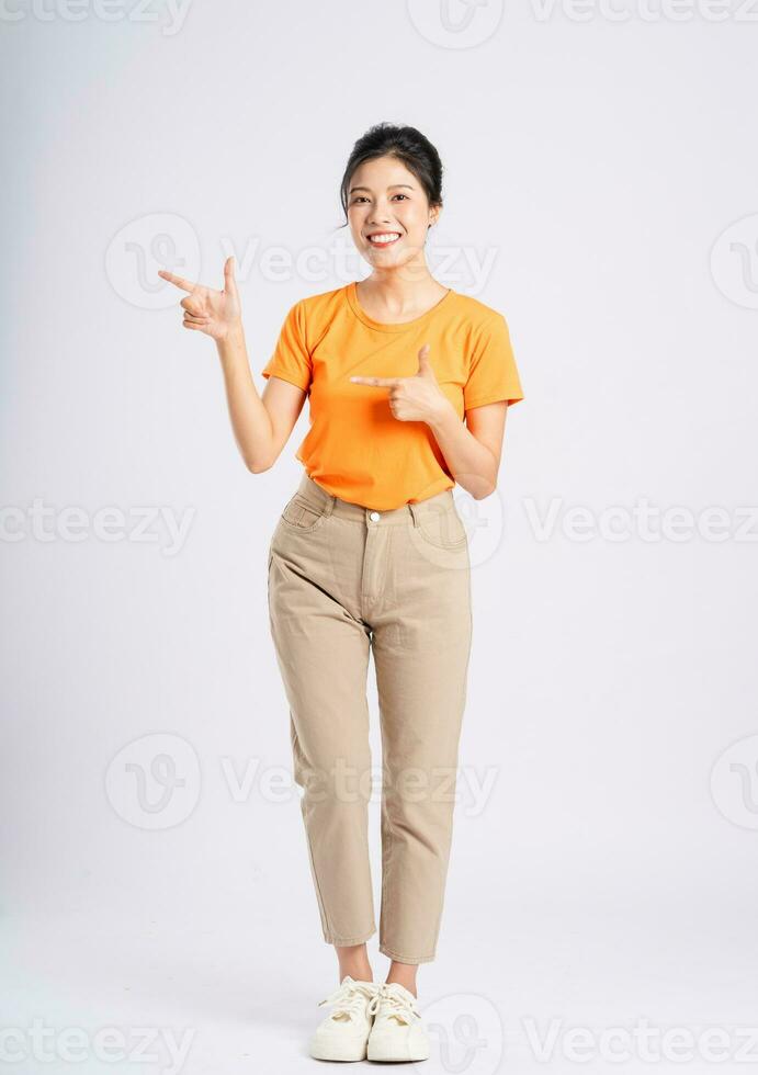 retrato de alegre contento asiático mujer posando en blanco antecedentes foto