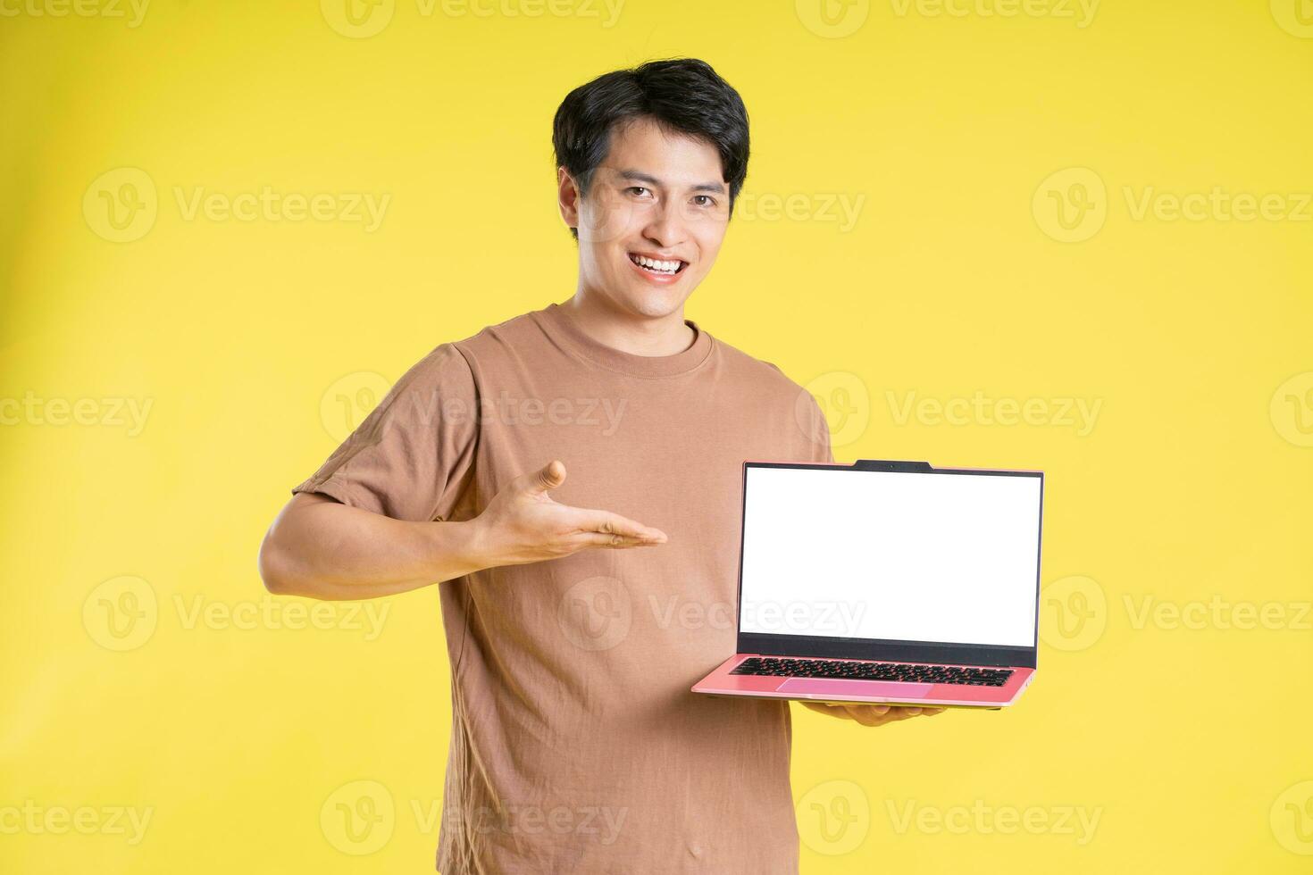 Portrait of asian man posing on yellow background photo