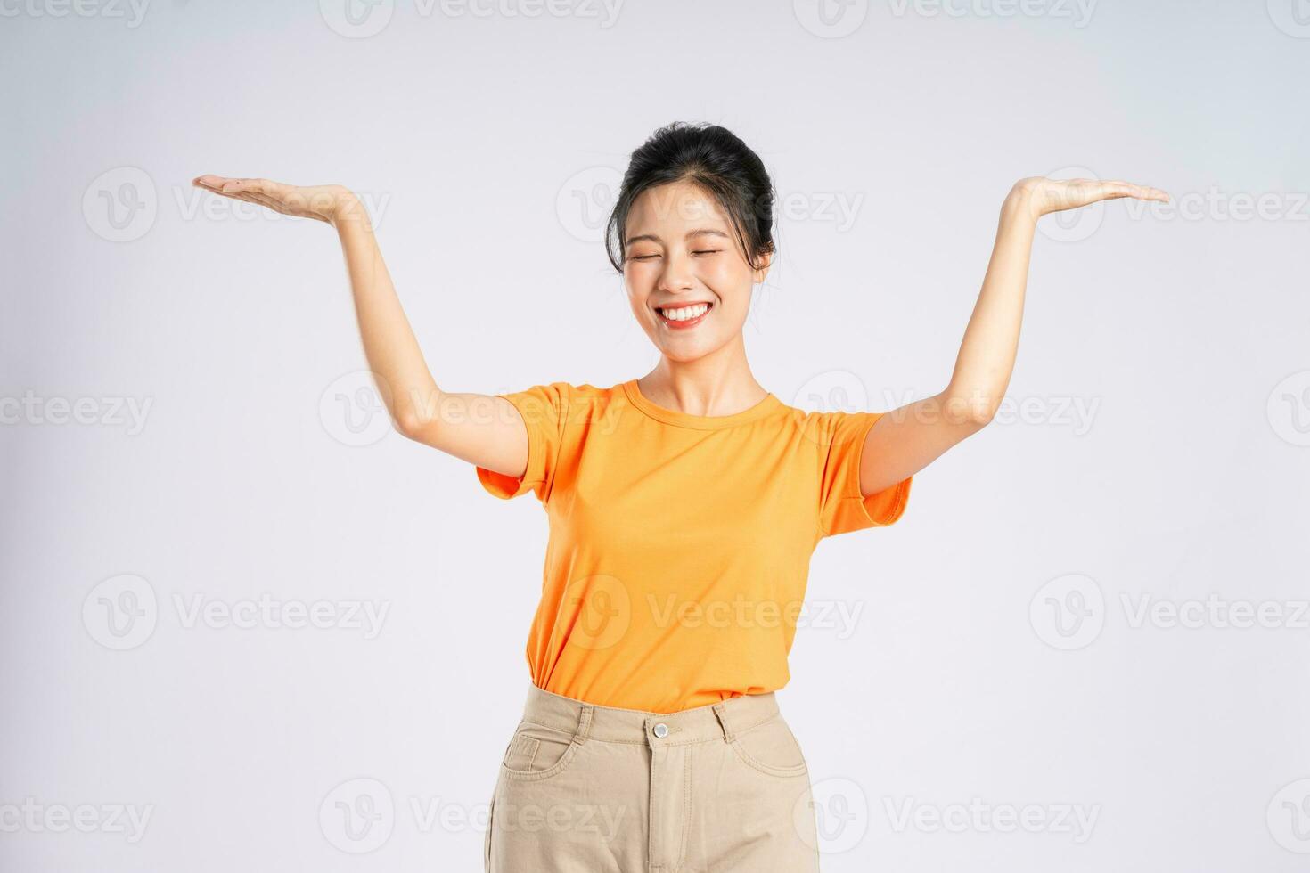 Portrait of cheerful happy Asian woman posing on white background photo