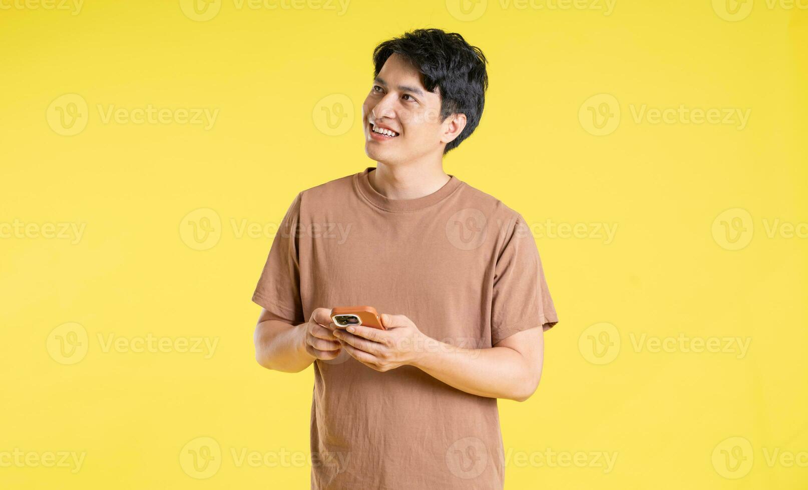 Portrait of asian man posing on yellow background photo