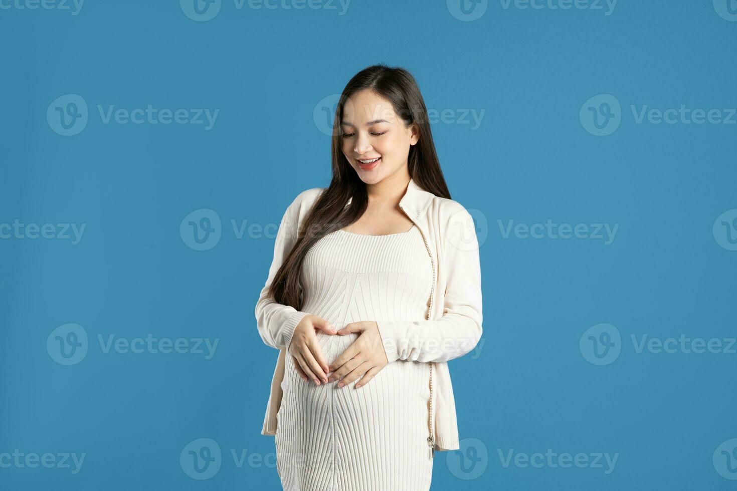 Portrait of pregnant asian woman, isolated on blue background photo