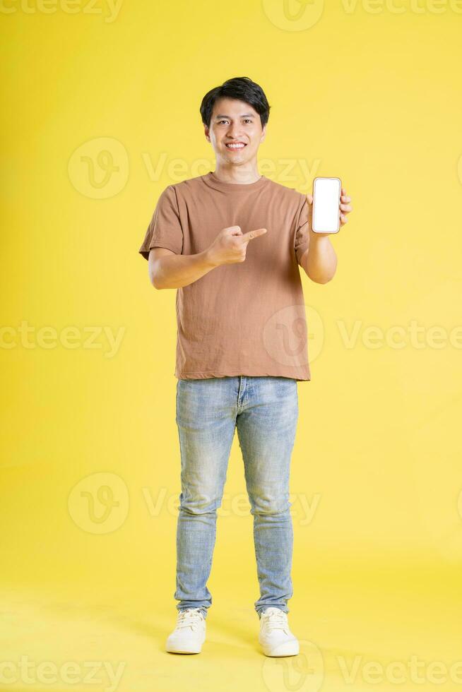 Portrait of asian man posing on yellow background photo