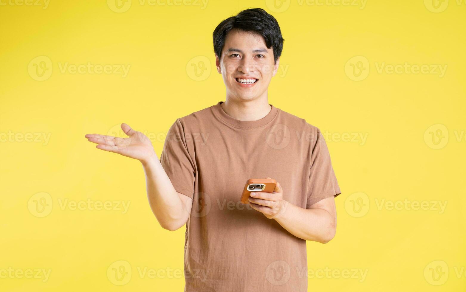 Portrait of asian man posing on yellow background photo