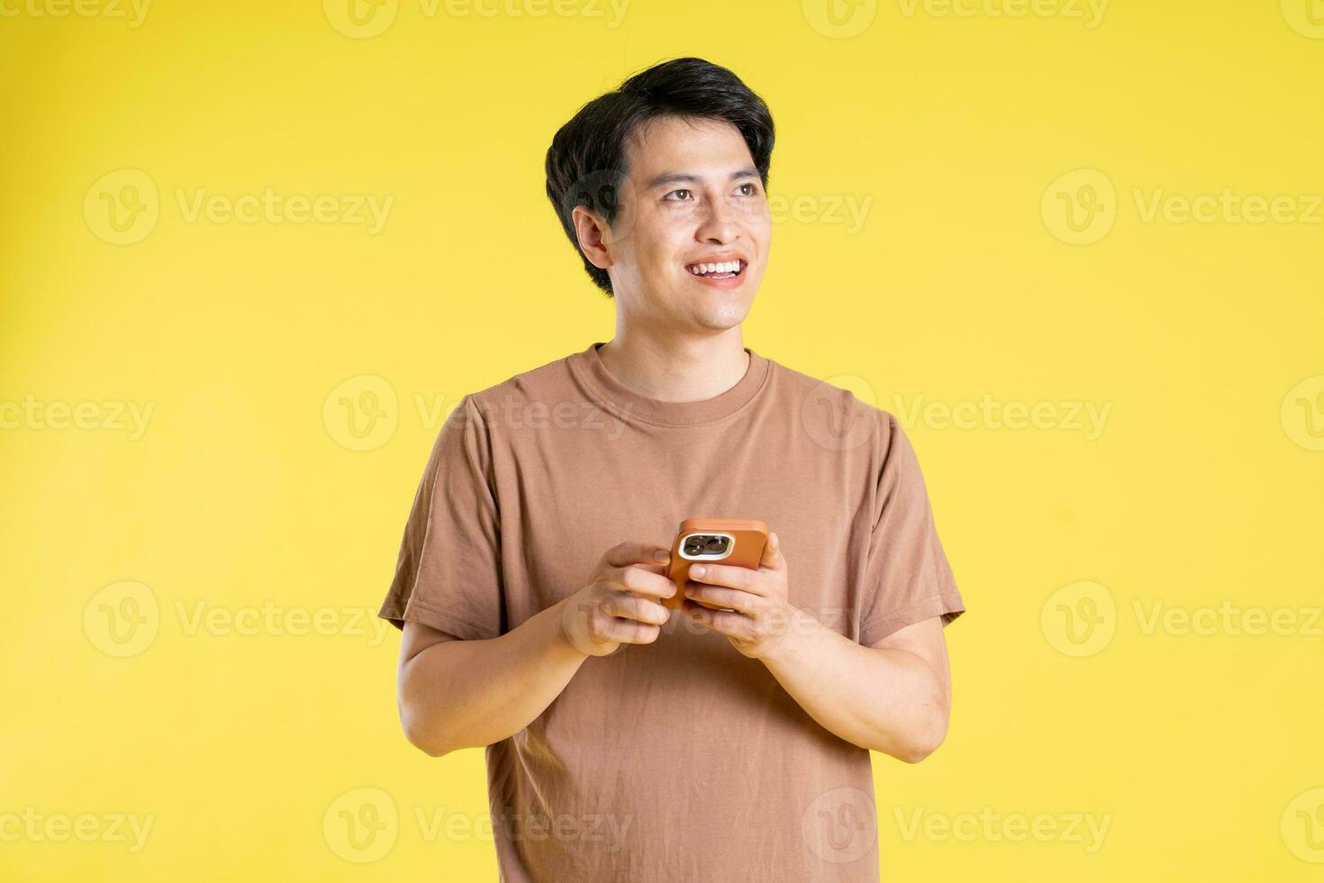 Portrait of asian man posing on yellow background photo