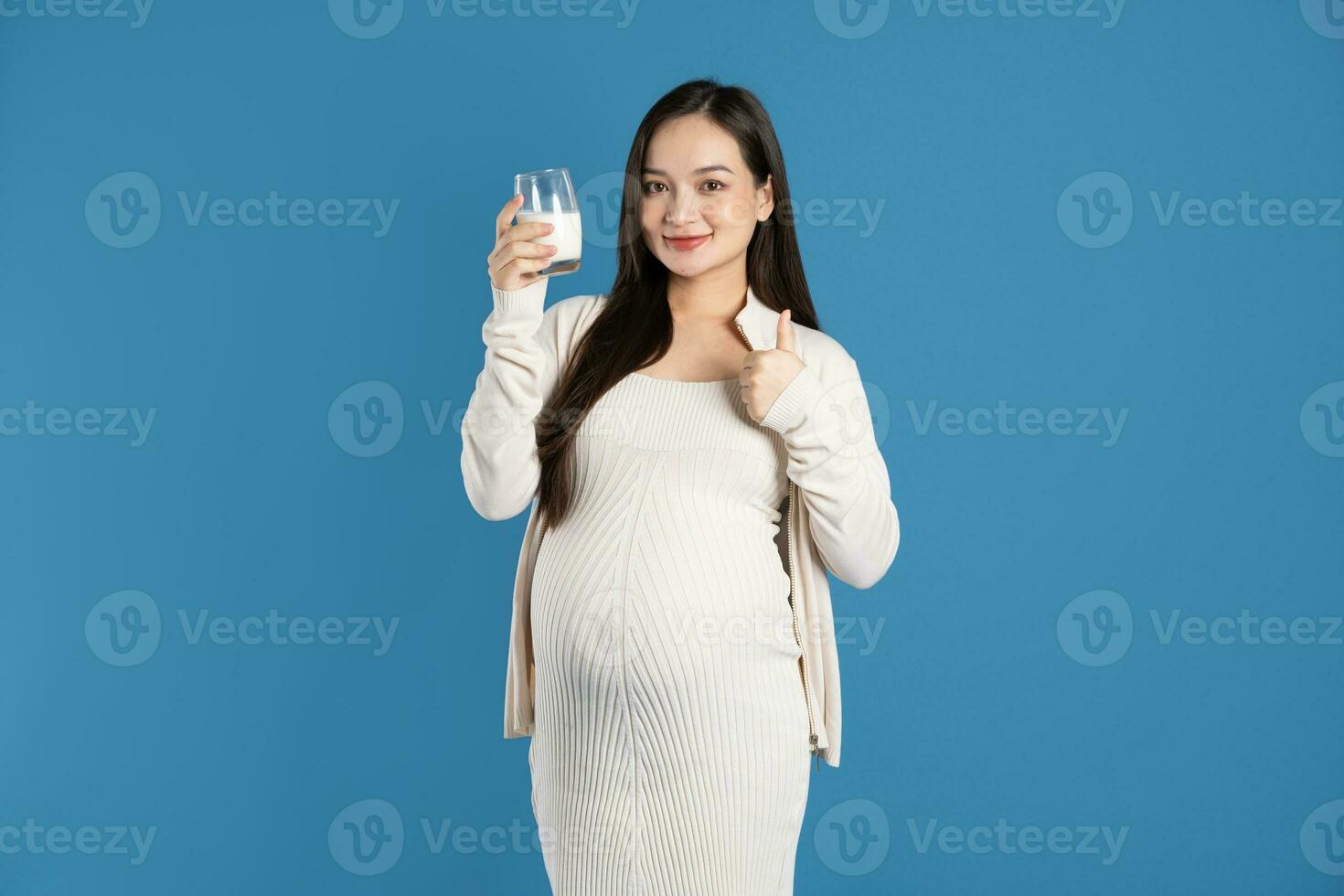 retrato de embarazada asiático mujer, aislado en azul antecedentes foto