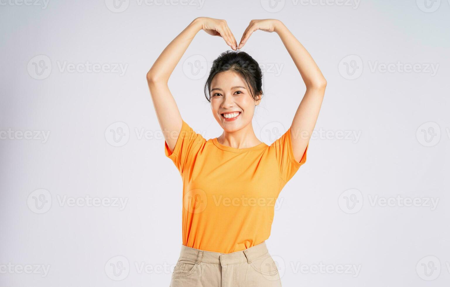 Portrait of cheerful happy Asian woman posing on white background photo