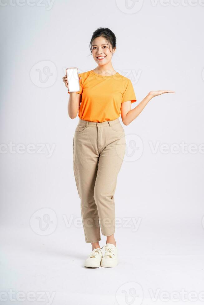 retrato de alegre contento asiático mujer posando en blanco antecedentes foto