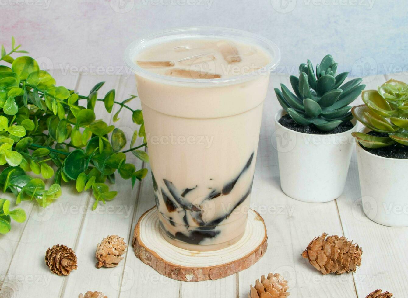frozen milk with grass jelly served om disposable glass isolated on wooden board top view of hong kong drink photo
