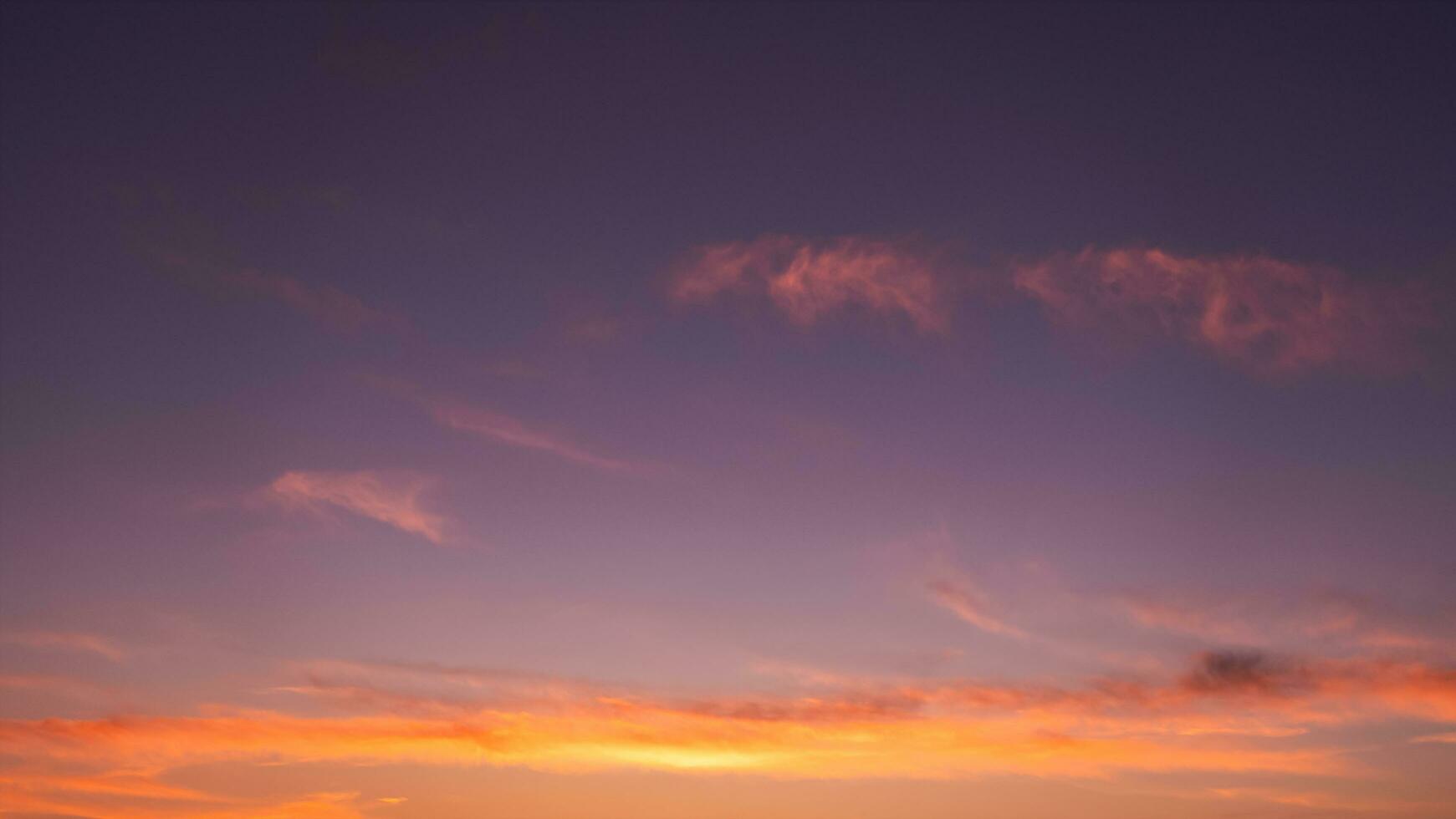 puesta de sol cielo, nubes en el noche ligero con naranja, amarillo y morado, hermoso naturaleza luz de sol en dorado hora después puesta de sol, horizonte romántico cielo con oscuridad crepúsculo en verano hora foto