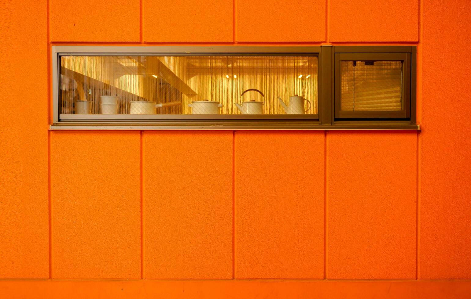 The orange outer wall of kitchen and window in wide angle shape. photo