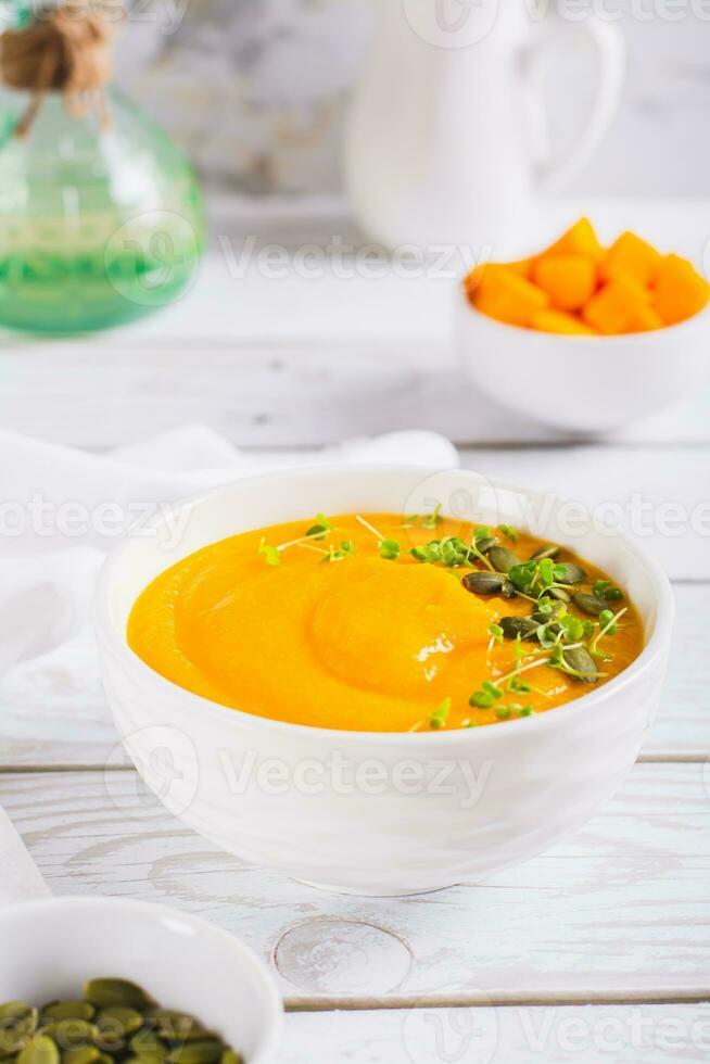 Homemade pumpkin polenta with seeds and microgreens in a bowl on the table vertical view photo