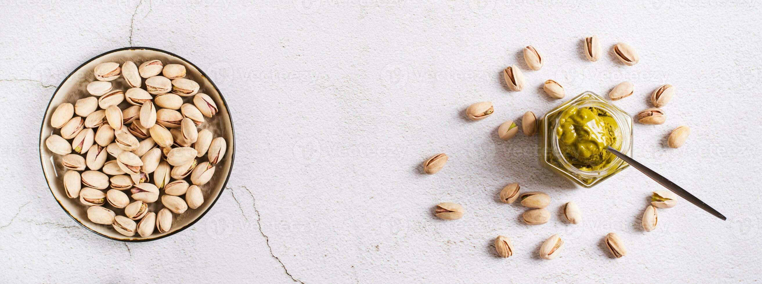 Jar with pistachio cream butter and pistachios on the table top view web banner photo