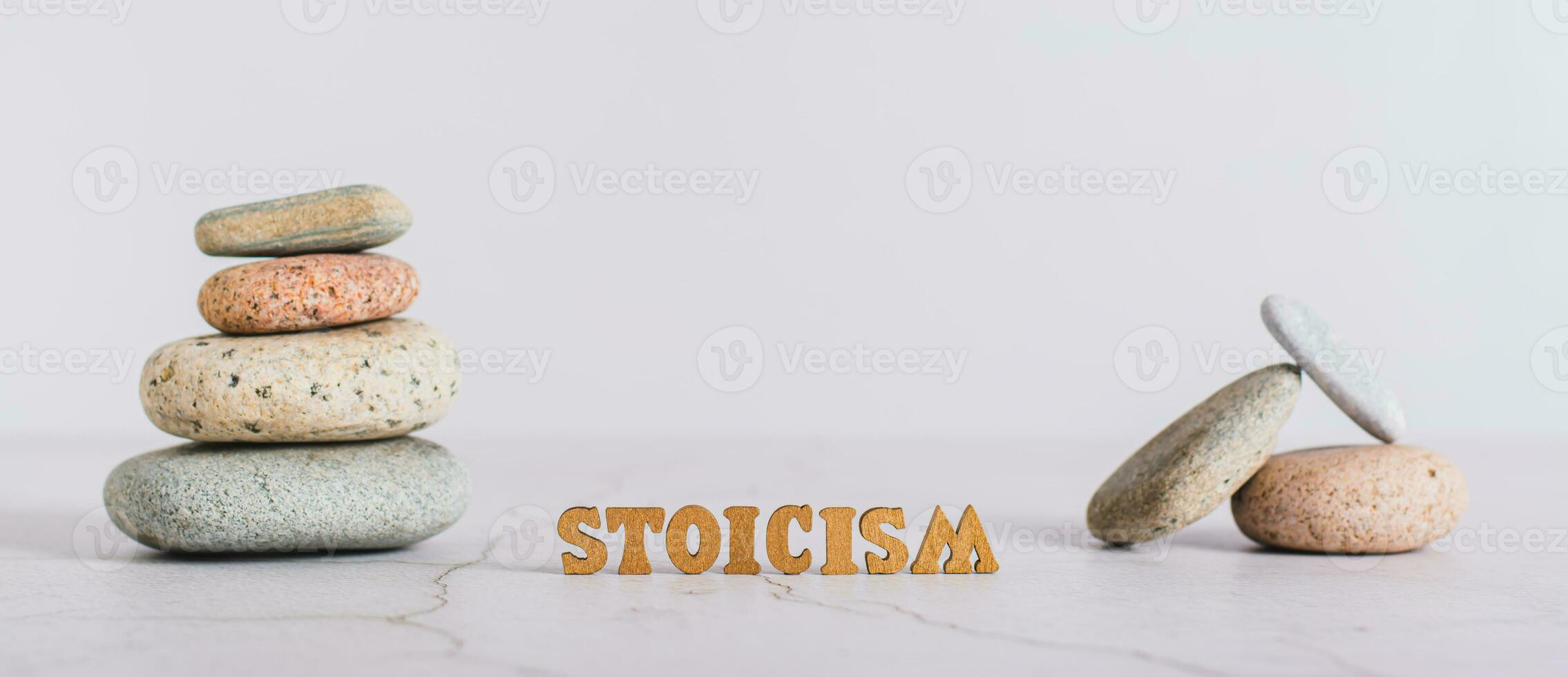 Concept stoicism word made from letters and pyramid of stones on gray background web banner photo