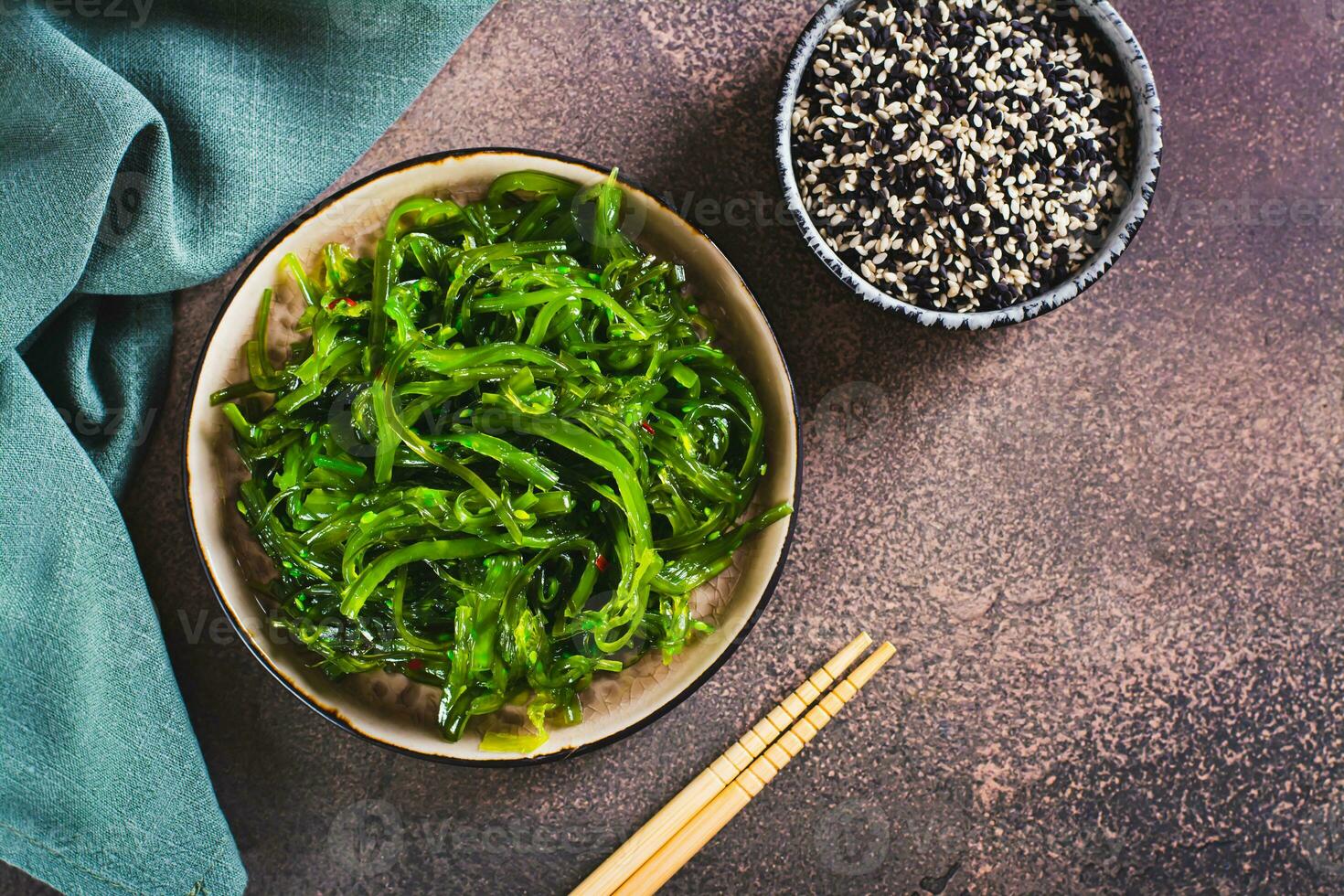 Traditional fresh seaweed and sesame salad on a plate on the table top view photo