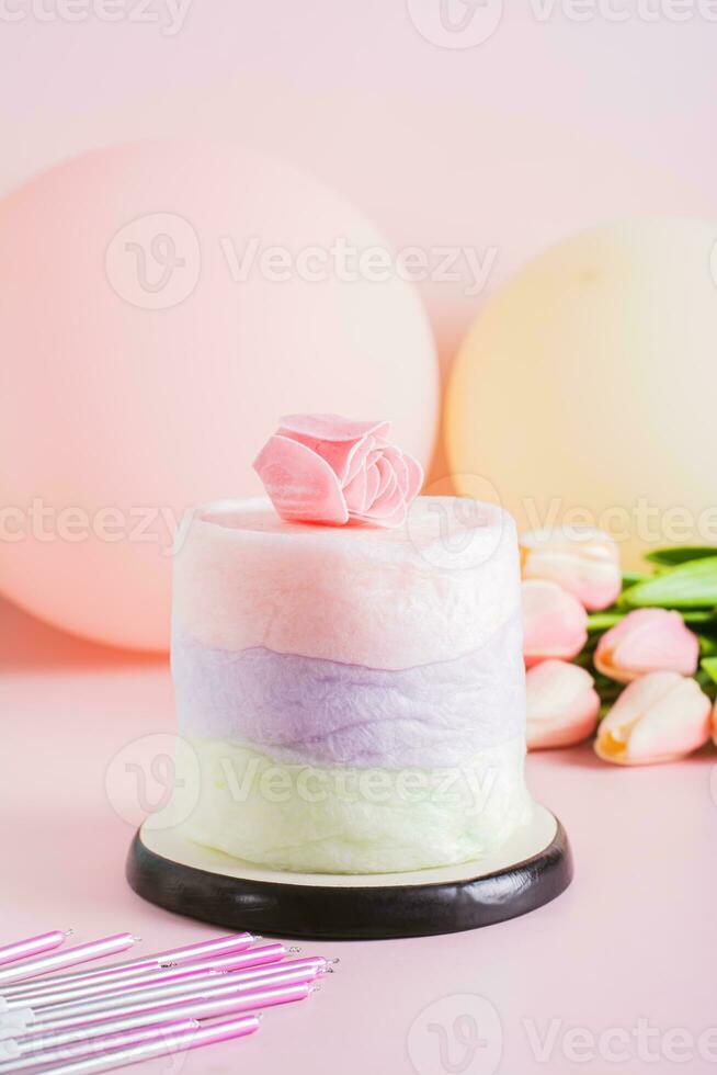 Colored cotton candy cake and party decorations on the table vertical view photo