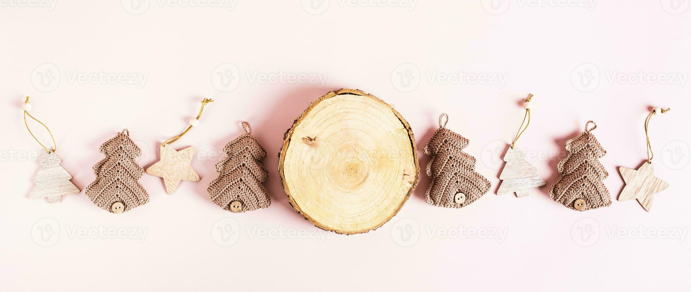 Tree trunk cut, knitted and wooden fir tree on pink background top view web banner photo