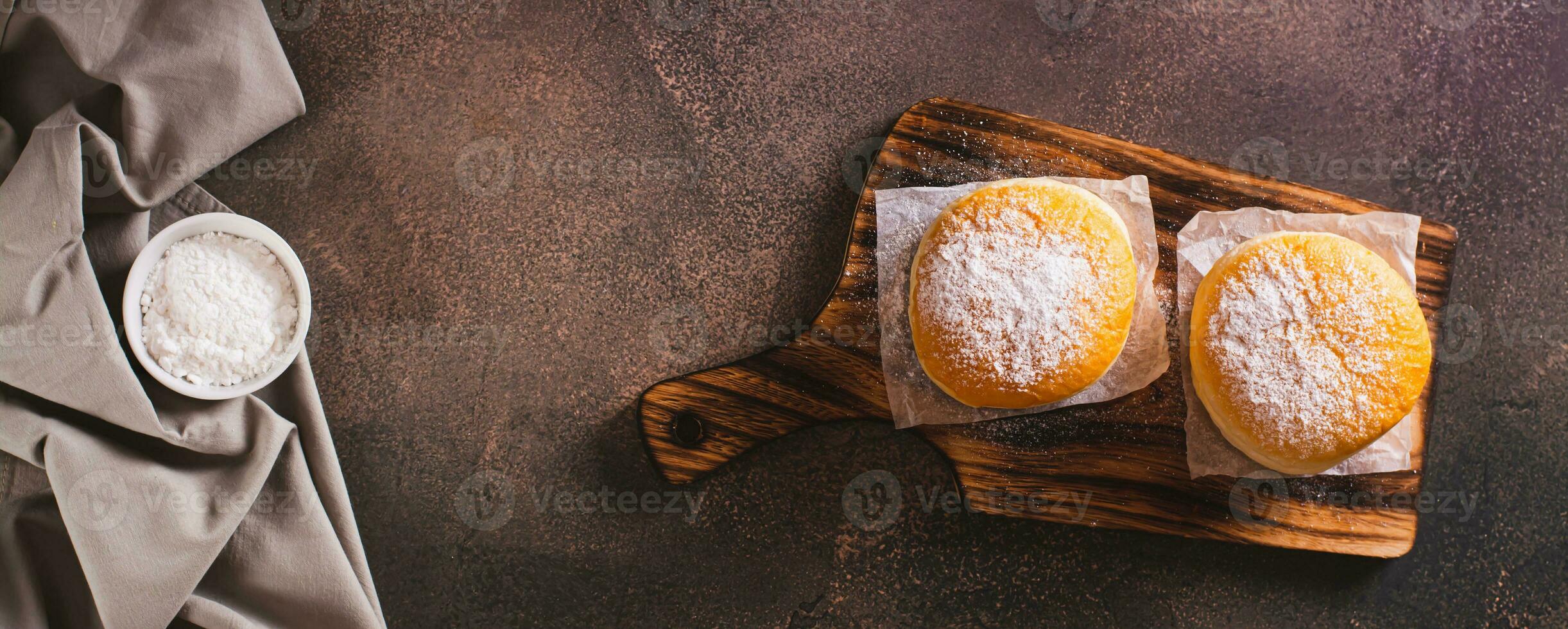 Fresco rosquillas con en polvo azúcar y dulce relleno en un plato en el mesa parte superior ver web bandera foto