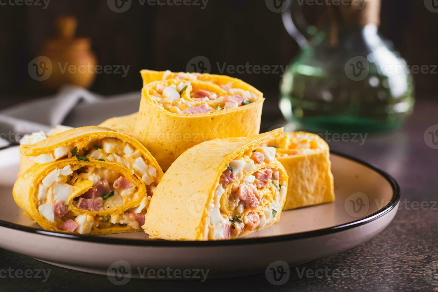Tortilla rolls with salad of sausages, eggs, cheese and herbs on a plate photo