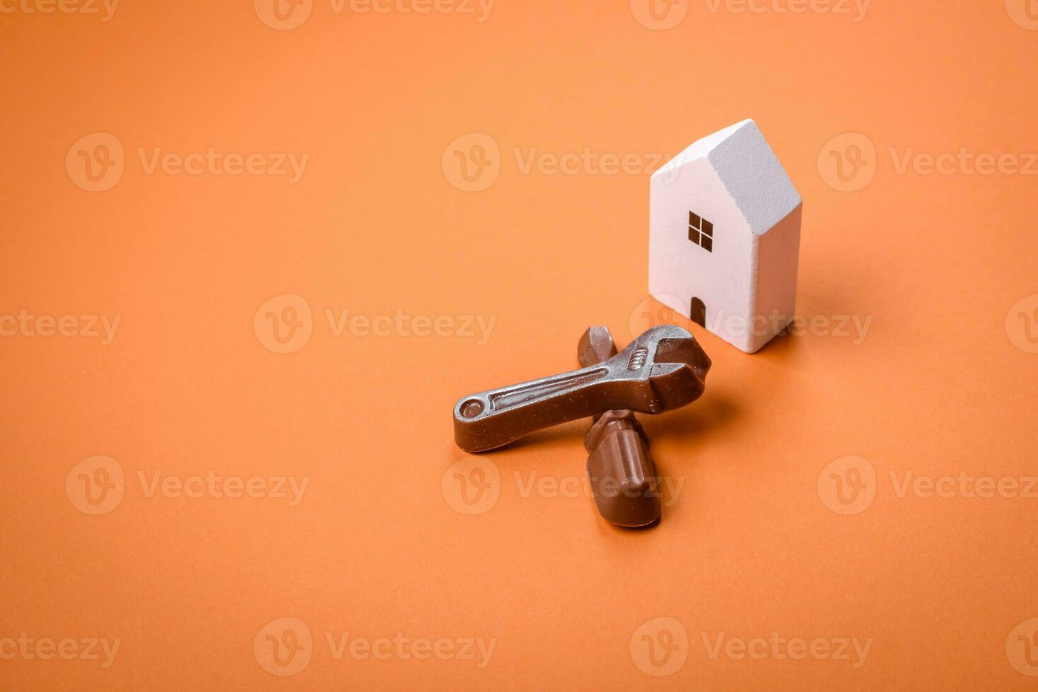 Repair or home improvement tools and a house model on a plain background photo