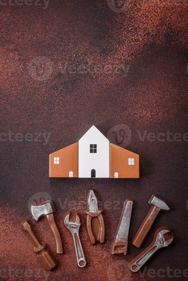 Repair or home improvement tools and a house model on a plain background photo