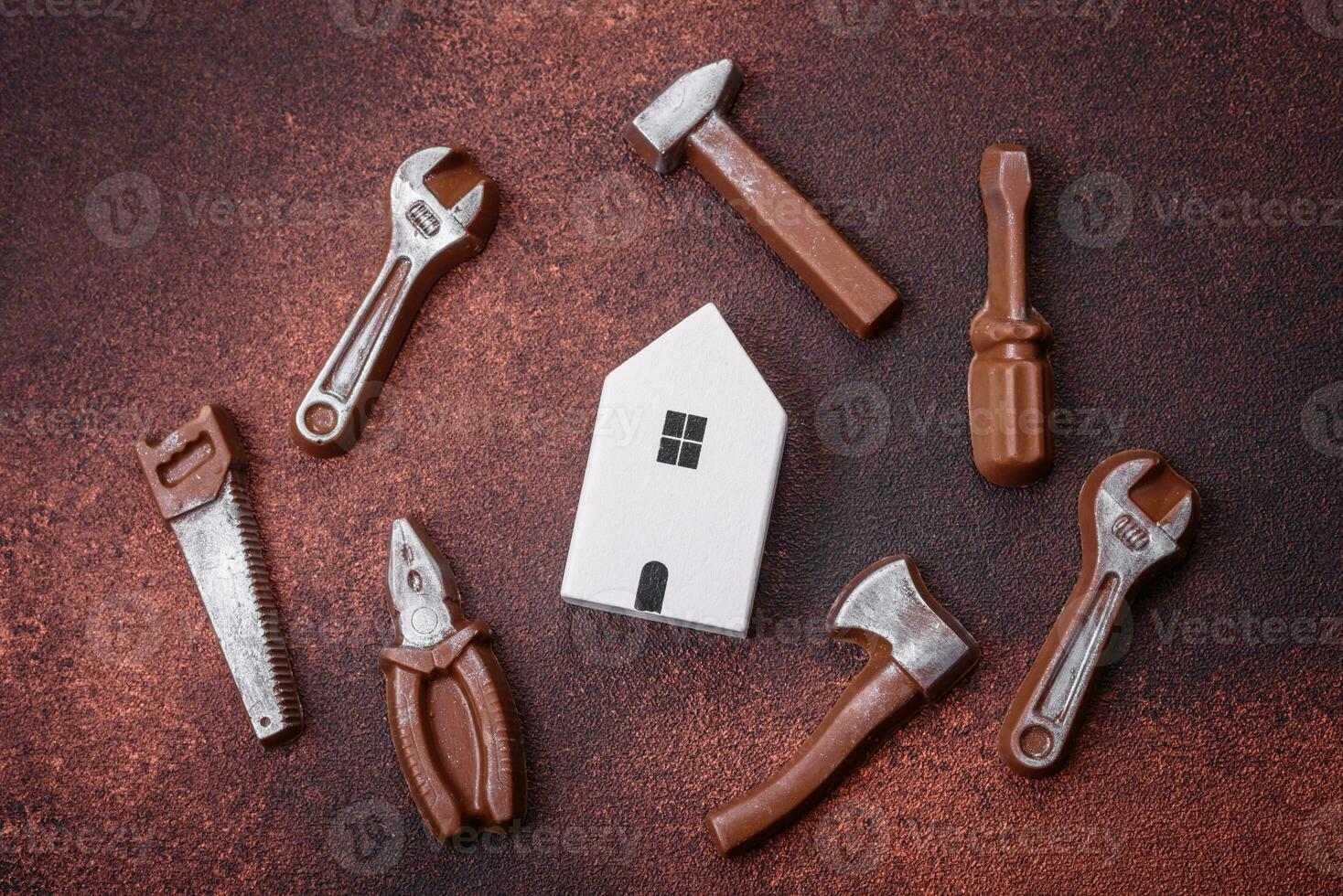 Repair or home improvement tools and a house model on a plain background photo